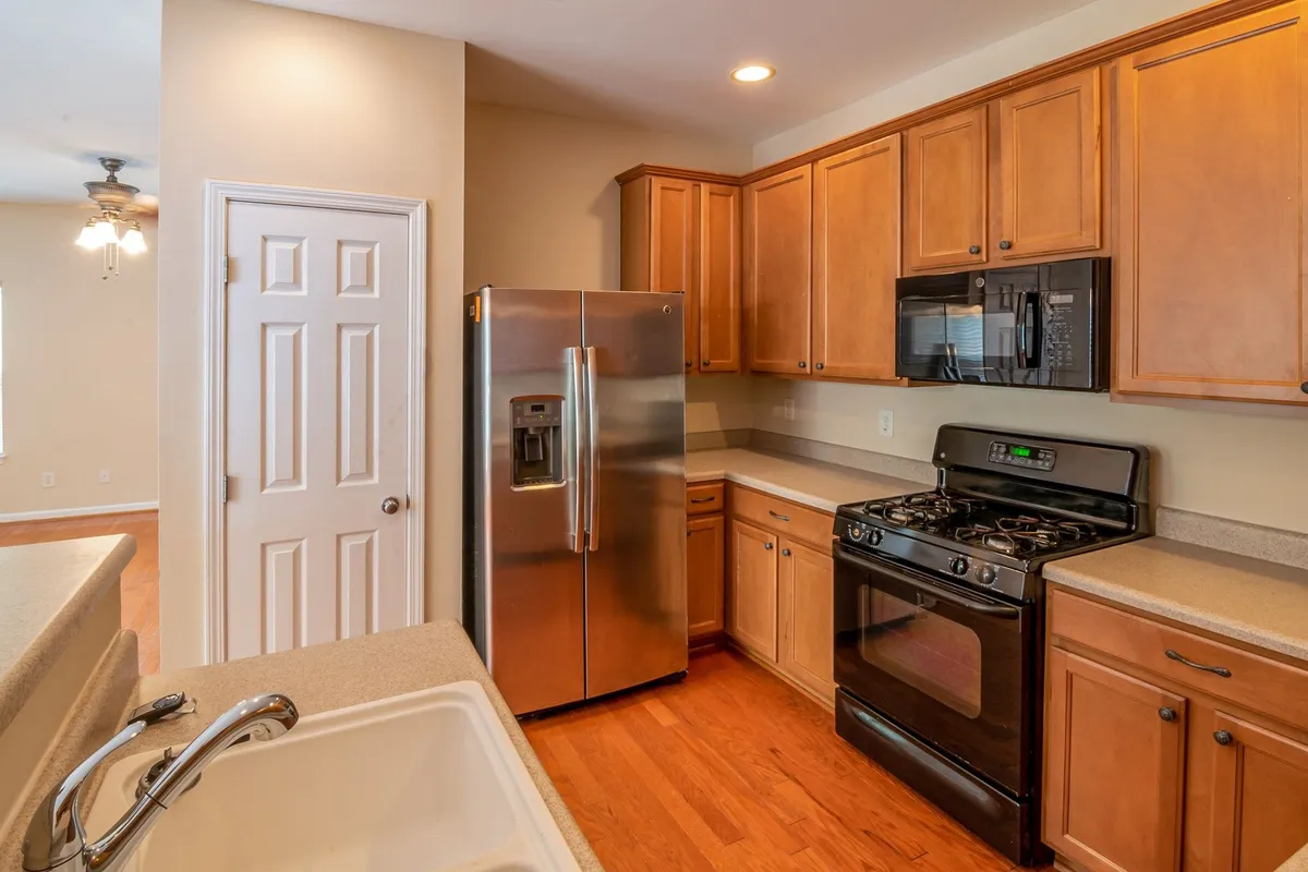 A modern kitchen with wooden cabinets and stainless steel appliances, highlighting the importance of affordable repairs.