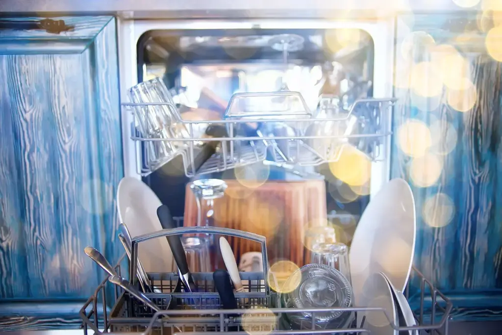 An open dishwasher filled with clean plates in a modern kitchen, highlighting the need for expert repair.